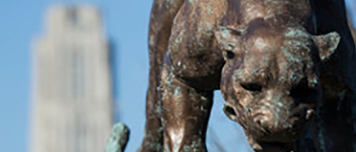 Statue of panther with cathedral of learning in backround