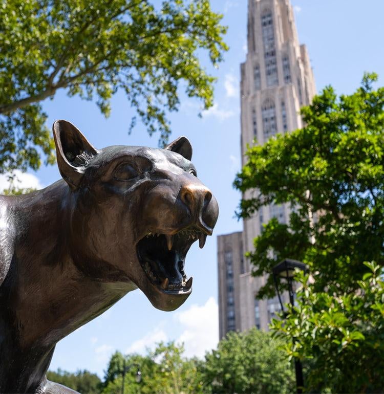 The Panther statue sits in the foreground of the Cathedral of Learning.